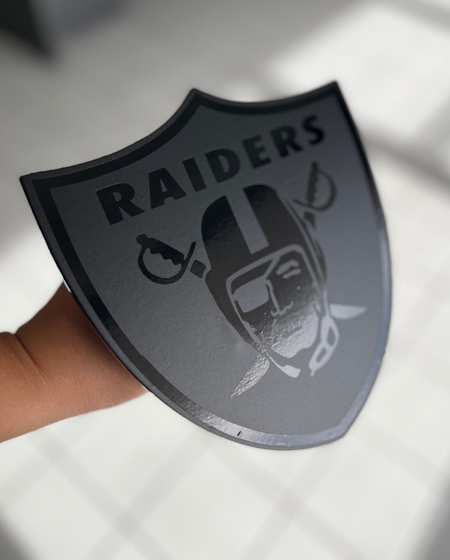 Black on black Raiders shield hitch cover